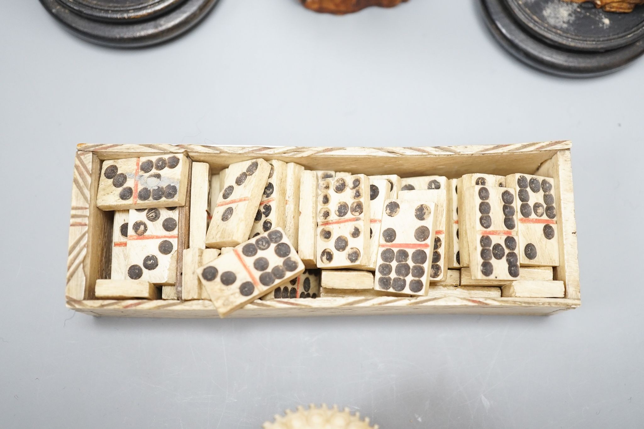 Three Chinese carved hippo tooth figures of Immortals, a 19th-century bone boxed dominoes set and a 19th-century ivory case set of dominoes